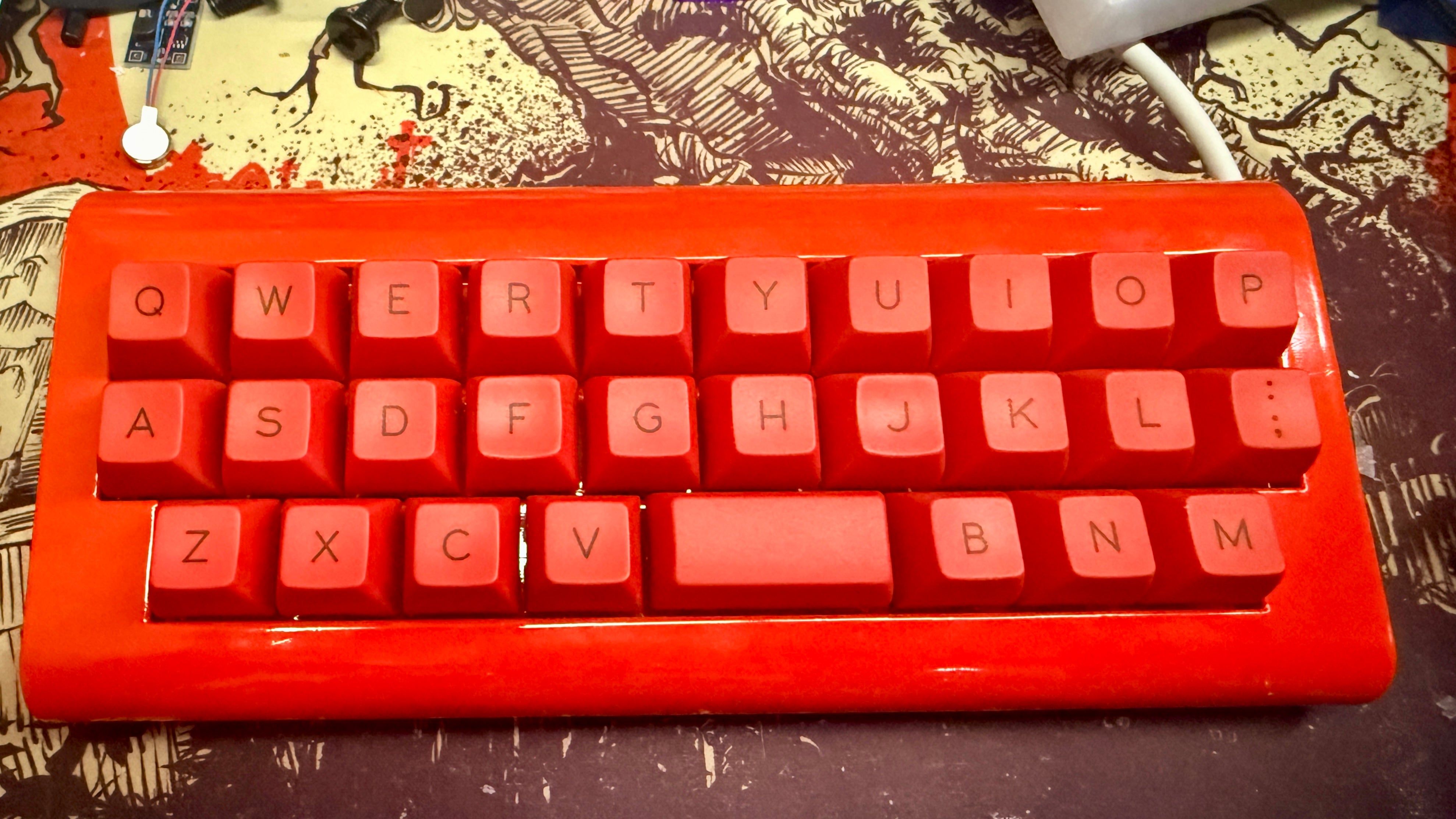 Red Alpha mechanical keyboard on a patterned surface.