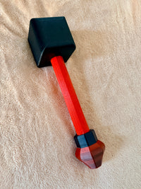 Black and red Hephaestus hammer on a beige background.
