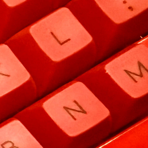 Close-up of red keyboard keys with 'L', 'M', and 'N' visible