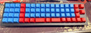 Mechanical keyboard with blue and red keys on a dark surface