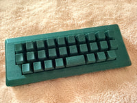 Custom green Alpha case with keys on a beige background.