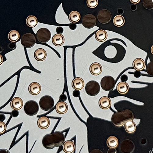Close-up of a decorative design with geometric shapes and patterns on a black background.