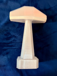 Thor hammer in metallic gold on a velvet blue background.